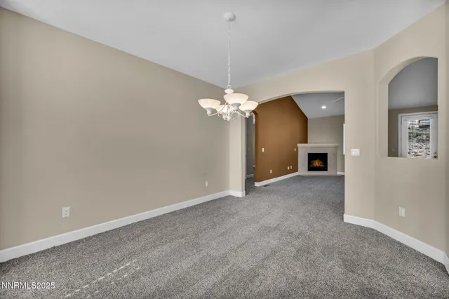 an empty room with windows and fireplace