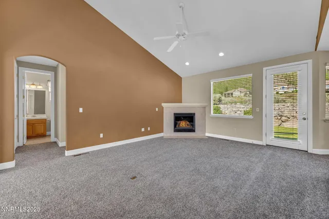 an empty room with windows and fireplace