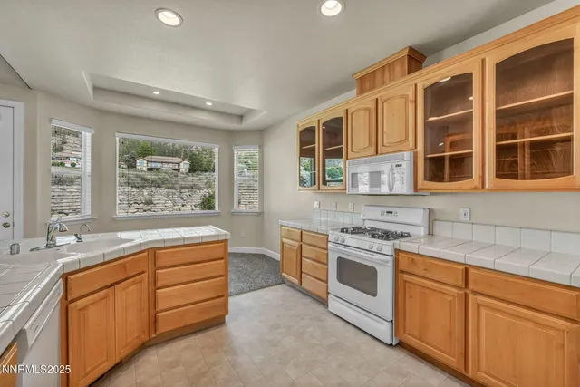 a bathroom with a granite countertop sink mirror and cabinets
