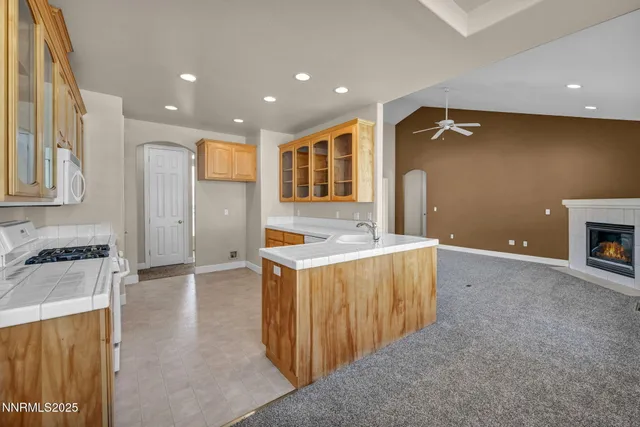 an empty room with chandelier fan and windows