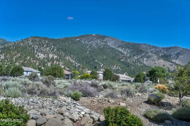 a view of a livingroom with a chandelier fan and windows