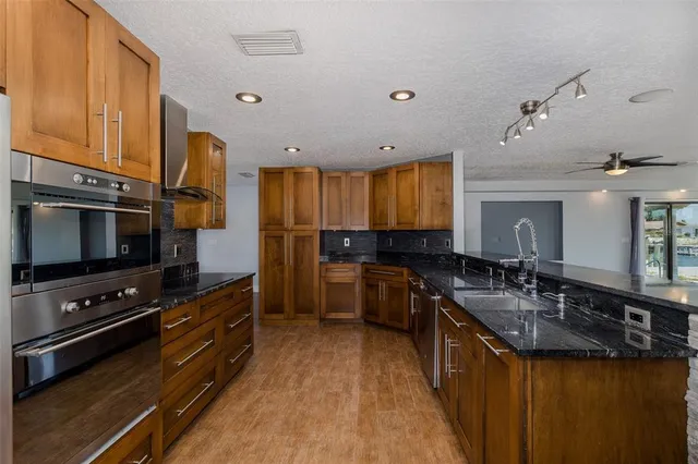 a kitchen with granite countertop a sink a counter and cabinets