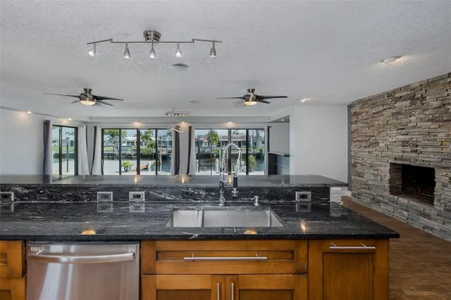a kitchen with granite countertop stainless steel appliances a sink stove and refrigerator