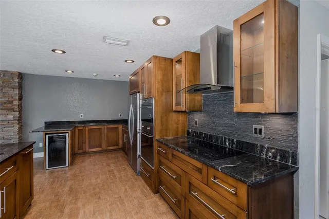 a large kitchen with stainless steel appliances a sink and cabinets