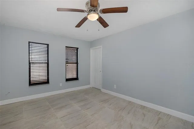an empty room with closet and a ceiling fan