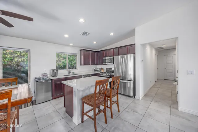 a kitchen with stainless steel appliances granite countertop a table and chairs
