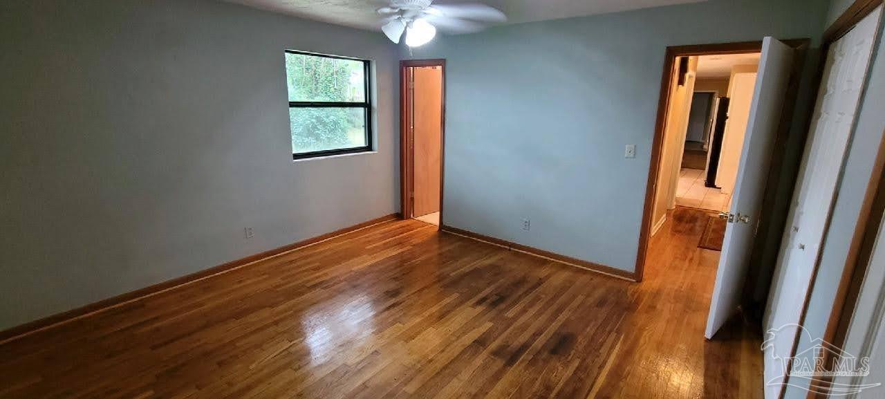 233 Cherokee Trail Pensacola, FL 32506 - Photo 24 of 36 an empty room with wooden floor and windows