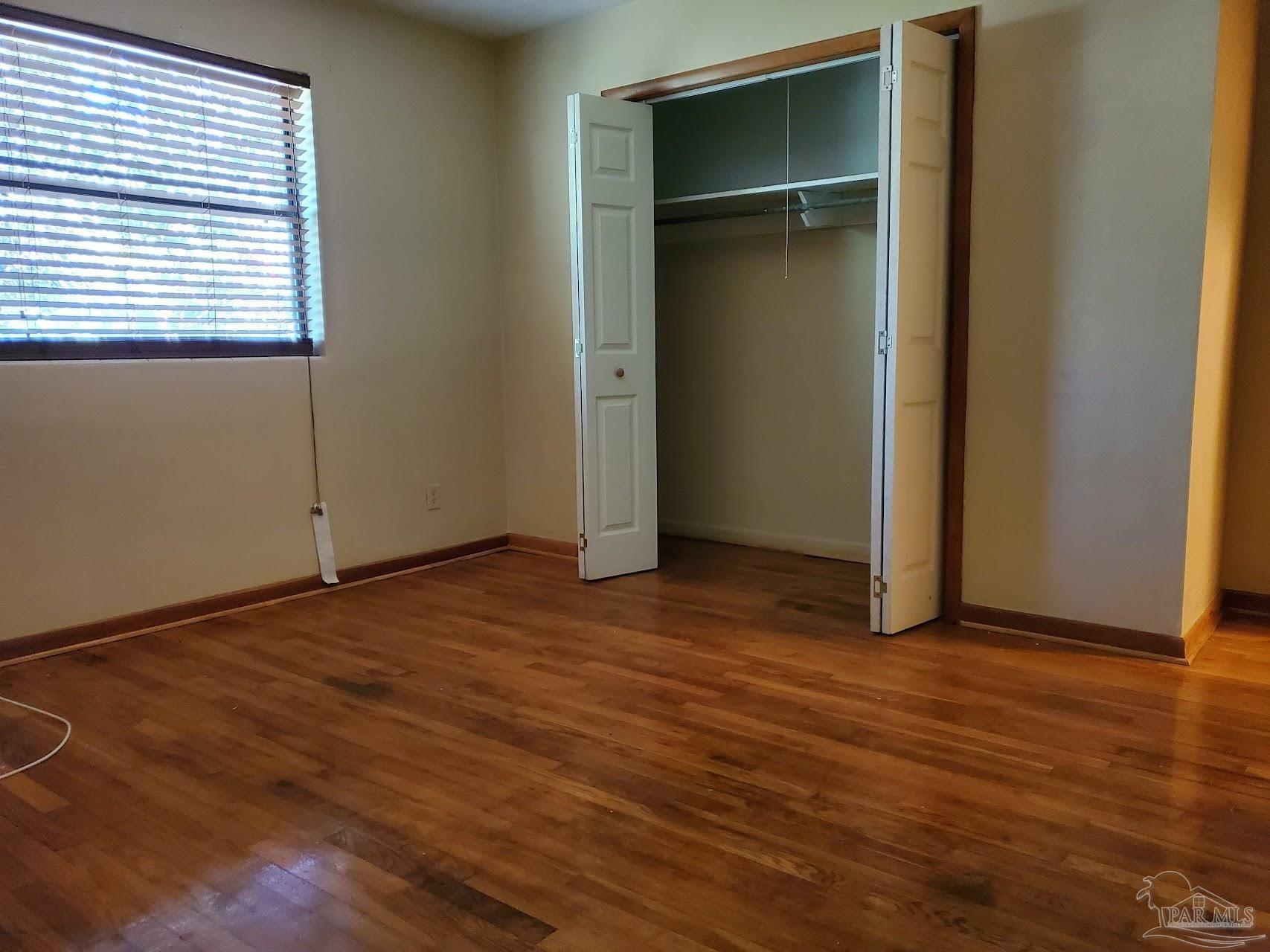 233 Cherokee Trail Pensacola, FL 32506 - Photo 31 of 36 an empty room with wooden floor & windows
