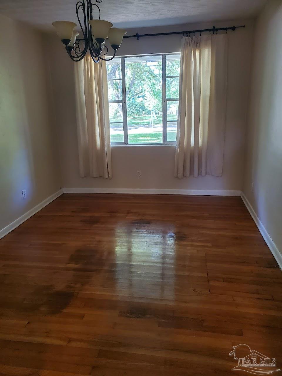 233 Cherokee Trail Pensacola, FL 32506 - Photo 6 of 36 a view of an empty room with wooden floor and a window