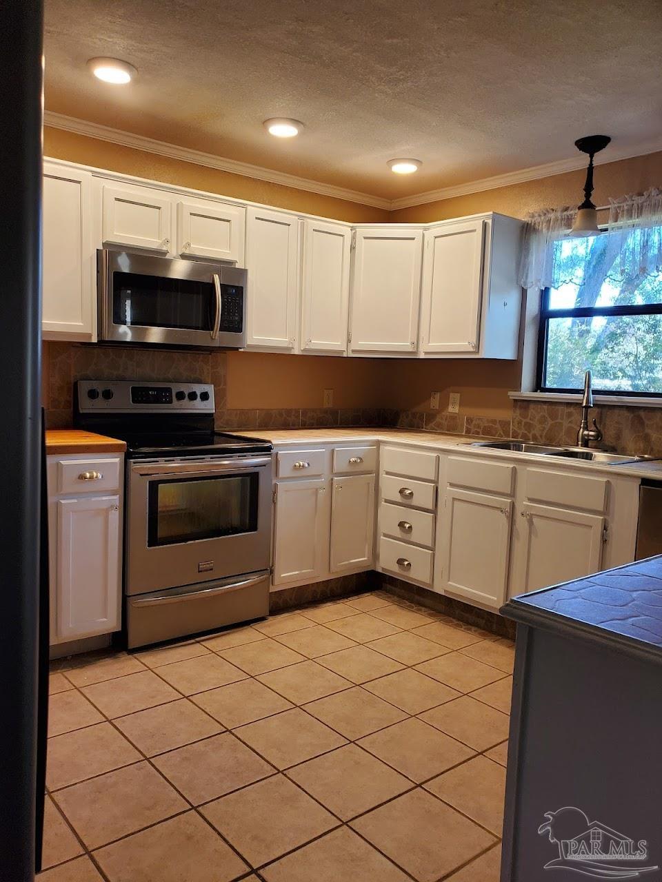 233 Cherokee Trail Pensacola, FL 32506 - Photo 7 of 36 a kitchen with stainless steel appliances a stove sink and microwave