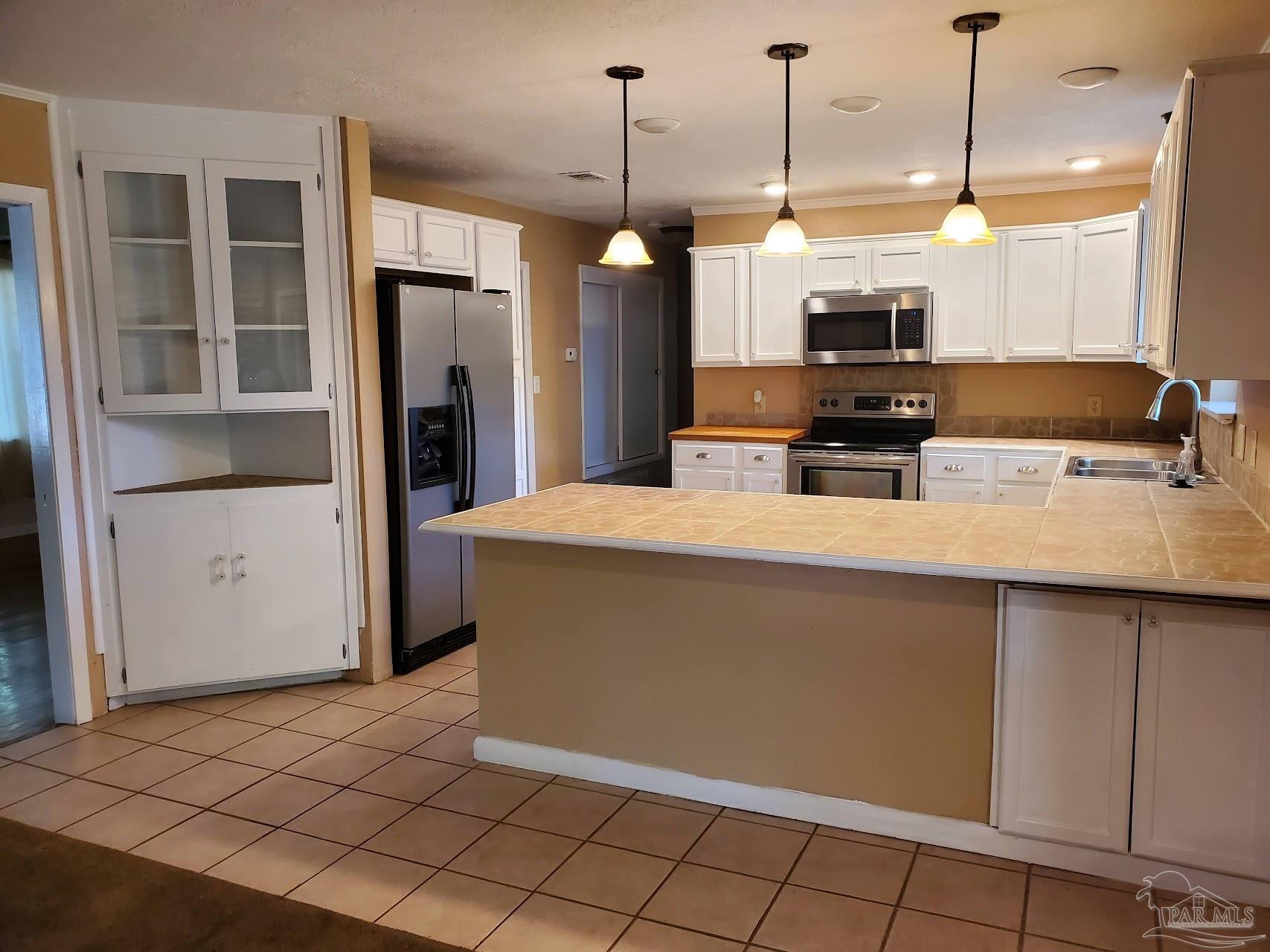 233 Cherokee Trail Pensacola, FL 32506 - Photo 8 of 36 a kitchen with stainless steel appliances a refrigerator a sink a stove a microwave and wooden cabinets