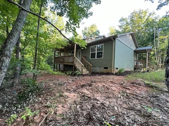 a view of a house with a yard and large trees