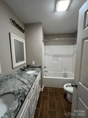 a bathroom with a granite countertop sink toilet and shower