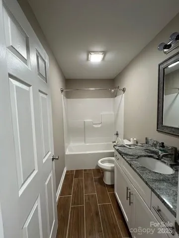 a bathroom with a sink a toilet a mirror and a bathtub