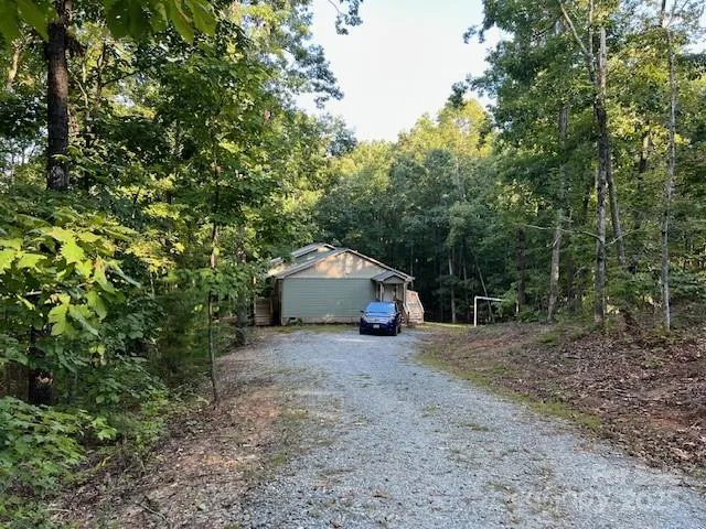 a view of a house with a yard and large tree