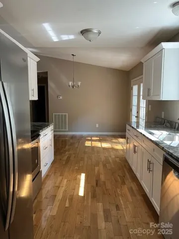 a kitchen with granite countertop a sink and refrigerator