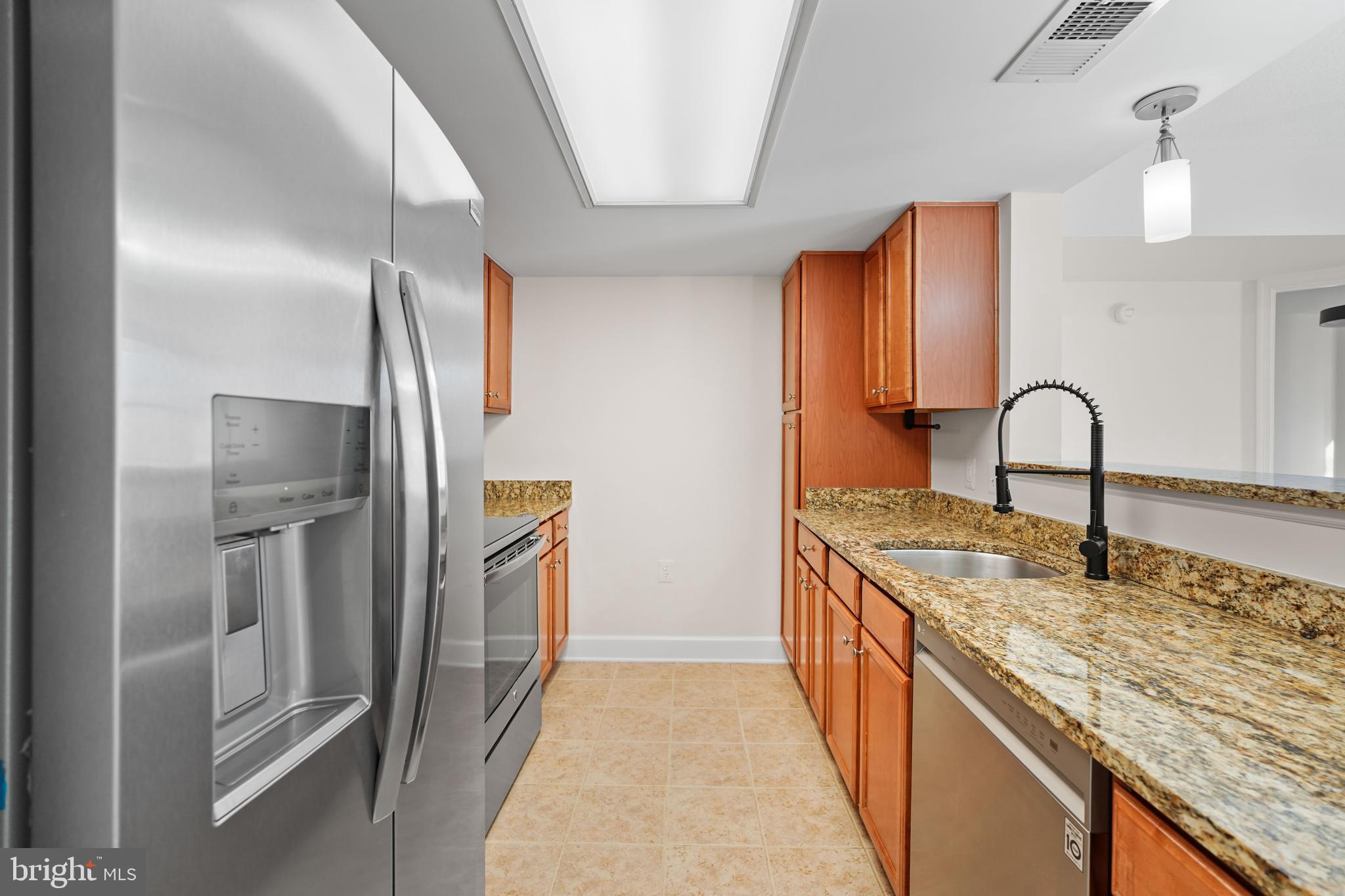 11800 Sunset Hills Road, Unit 611 Reston, VA 20190 - Photo 12 of 40 a kitchen with stainless steel appliances granite countertop a sink and a refrigerator