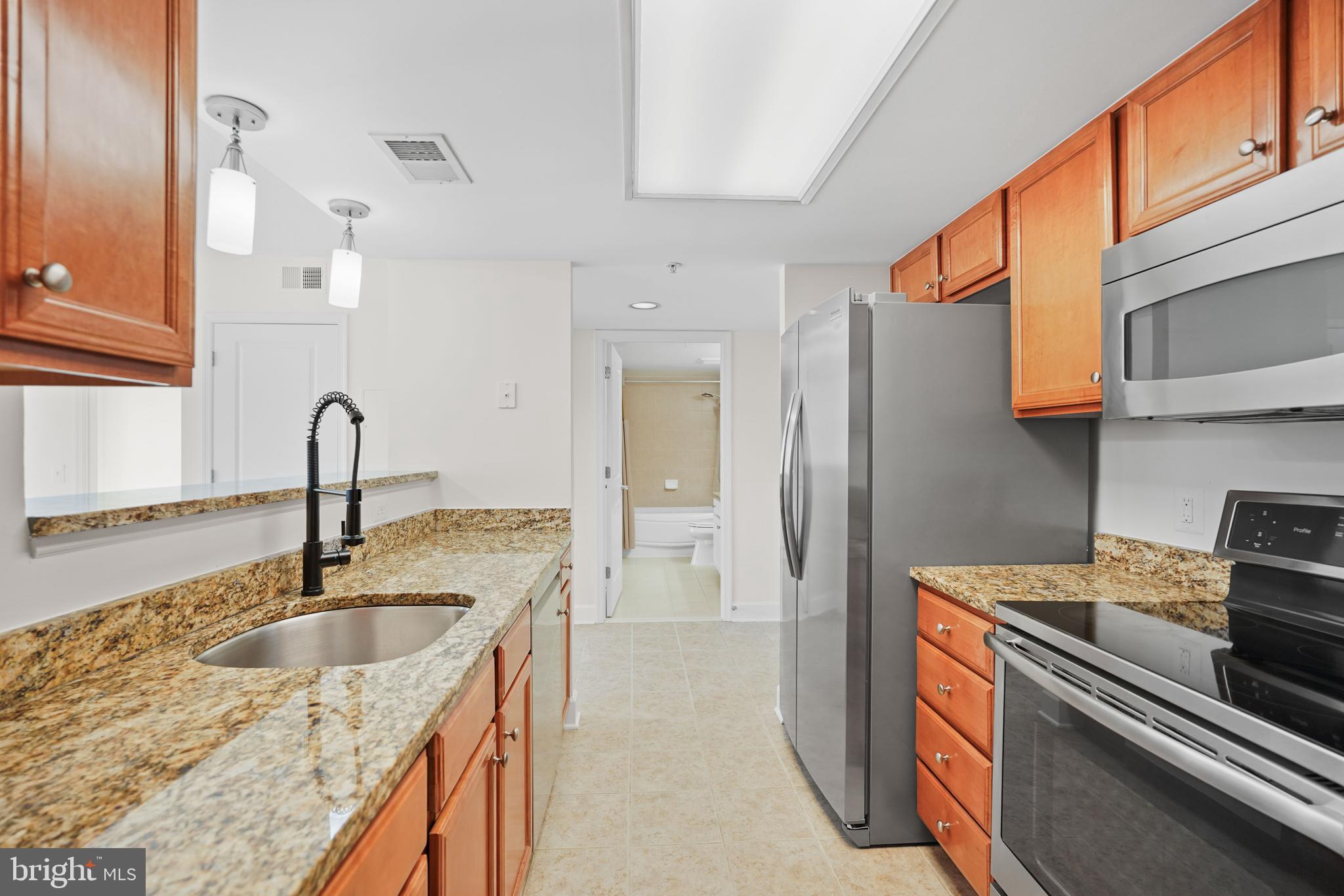 11800 Sunset Hills Road, Unit 611 Reston, VA 20190 - Photo 13 of 40 a kitchen with sink a refrigerator and a stove