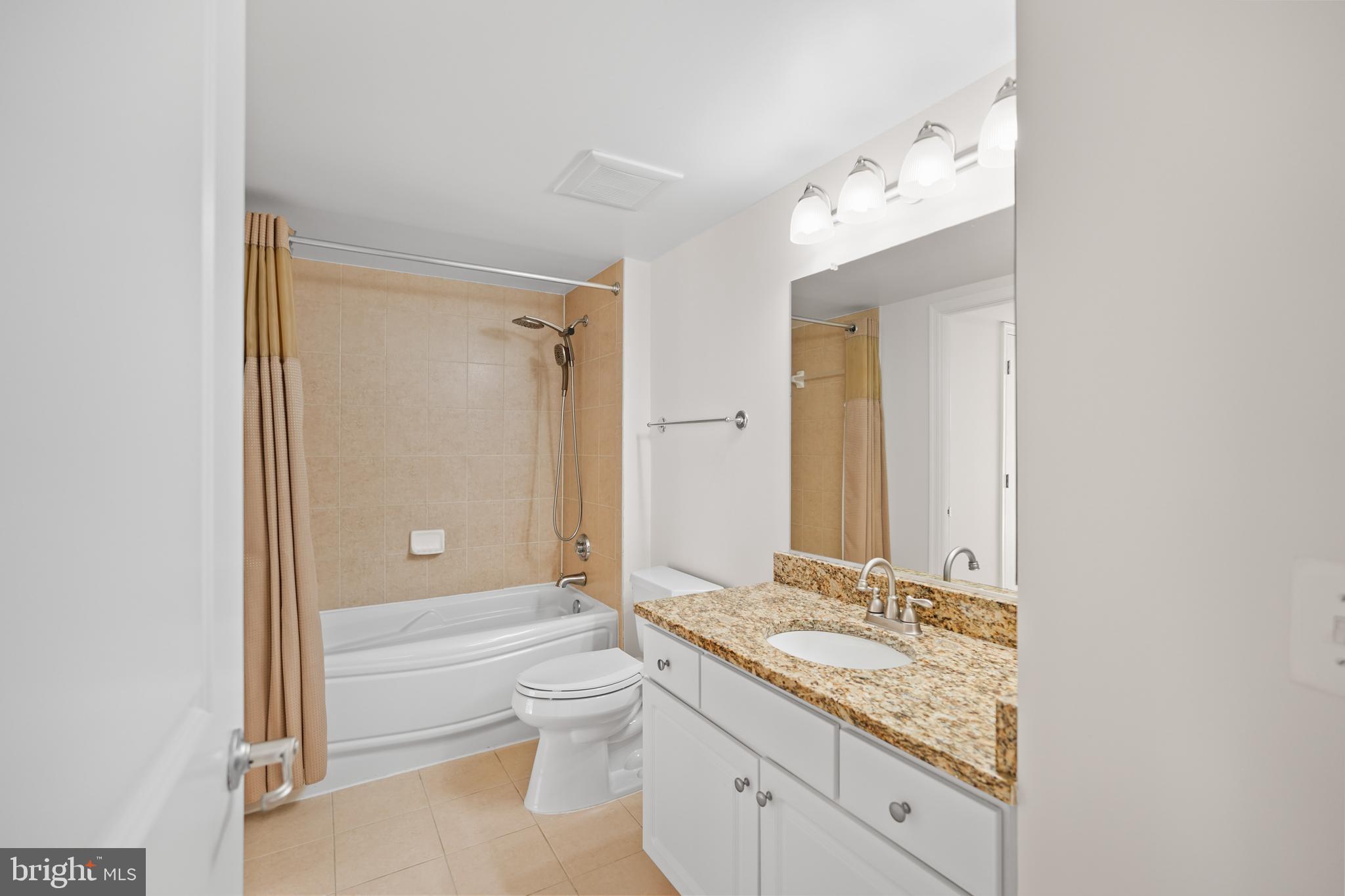 11800 Sunset Hills Road, Unit 611 Reston, VA 20190 - Photo 16 of 40 a bathroom with a granite countertop sink a mirror and a bathtub