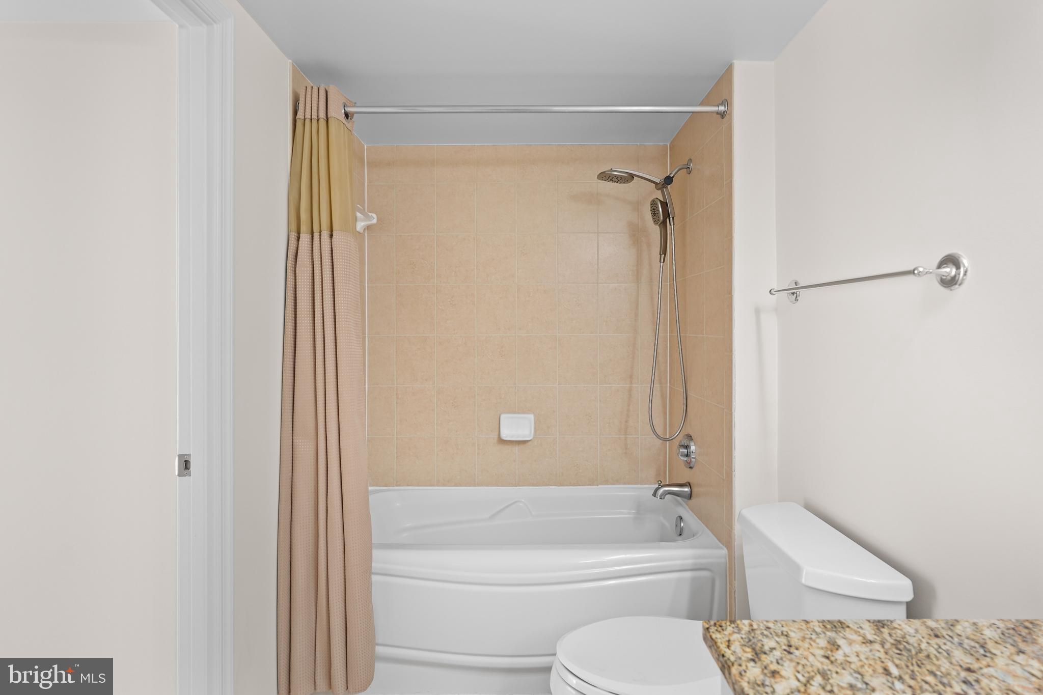 11800 Sunset Hills Road, Unit 611 Reston, VA 20190 - Photo 17 of 40 a bathroom with a granite countertop bathtub shower and toilet