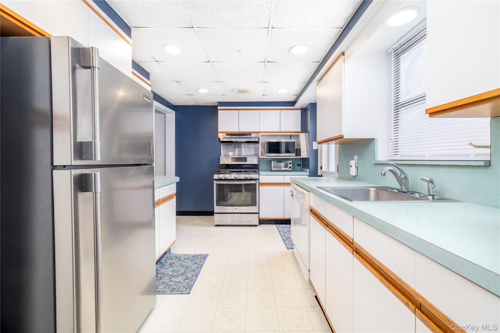 135 Chestnut Street Lynbrook, NY 11563 - Photo 7 of 18 a kitchen with stainless steel appliances granite countertop a sink refrigerator and cabinets