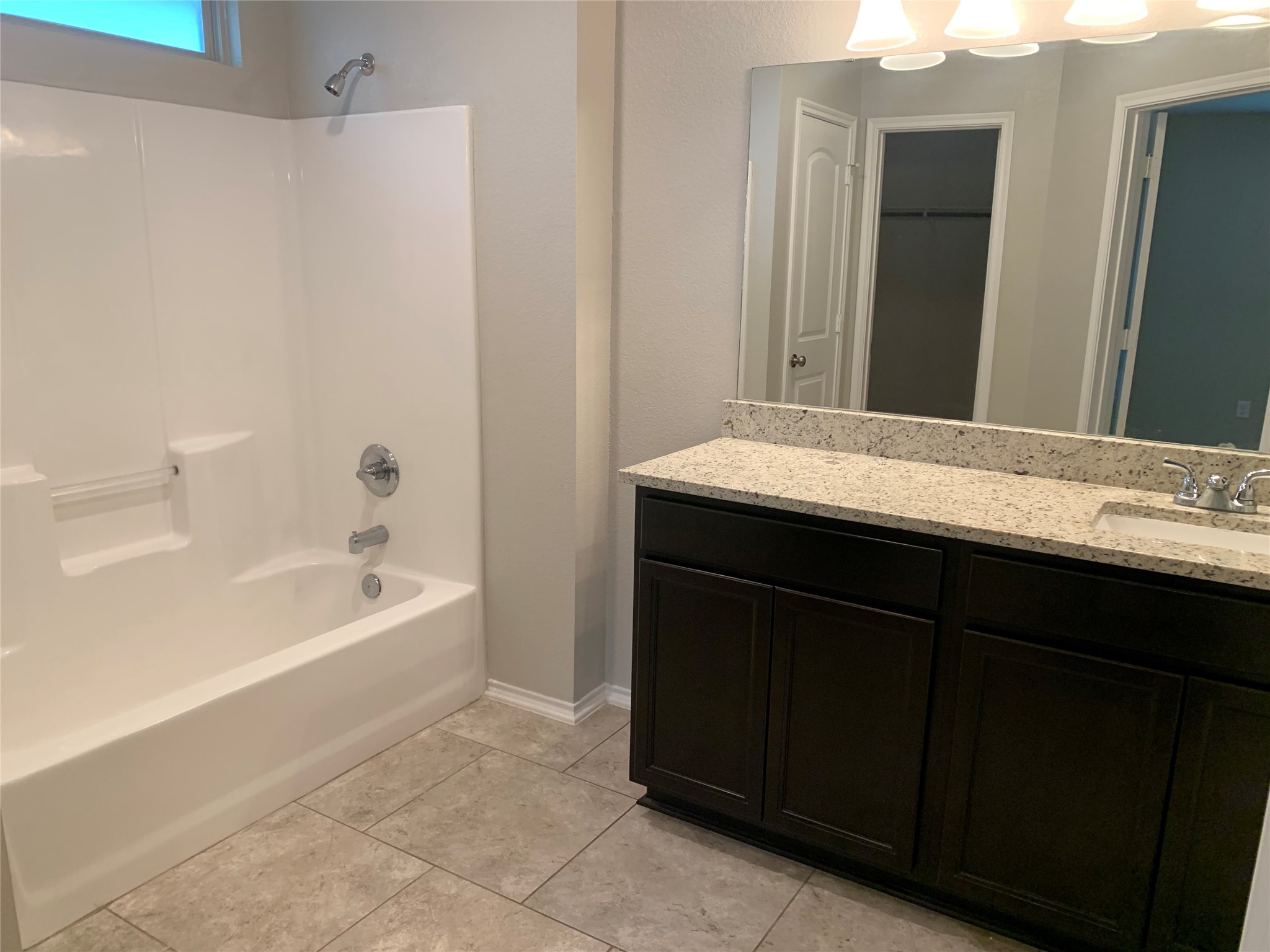 1929 Briar Grove Drive Conroe, TX 77301 - Photo 13 of 17 a bathroom with a granite countertop sink a mirror and a bathtub
