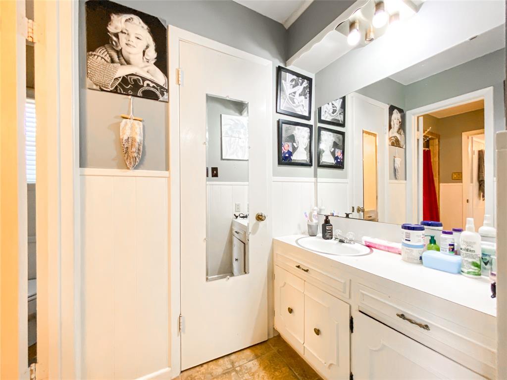 4301 Caprock Road Abilene, TX 79606 - Photo 18 of 29 Bathroom vanity featuring a built-in sink, white cabinetry, and a large wall-mounted mirror