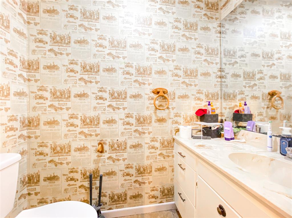 4301 Caprock Road Abilene, TX 79606 - Photo 22 of 29 Bathroom featuring a single vanity with a built-in sink, stone-finish countertop, and white cabinetry