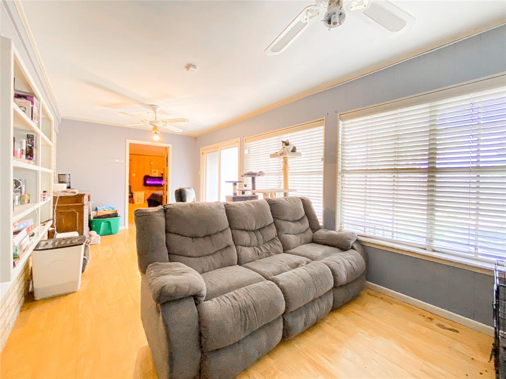 4301 Caprock Road Abilene, TX 79606 - Photo 24 of 29 Living area featuring multiple windows, wood-finish flooring, two ceiling fans, and built-in shelving