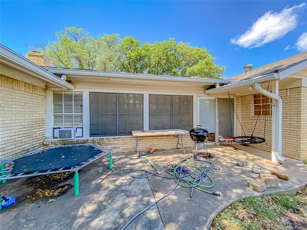 4301 Caprock Road Abilene, TX 79606 - Photo 28 of 29 Brick exterior featuring a concrete patio, white gutters, and a sliding glass door