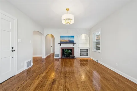 a view of an empty room with a fireplace and a window