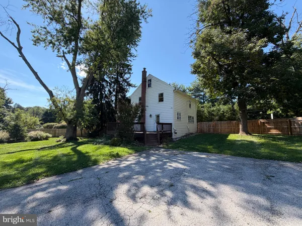 a view of a house with backyard and trees