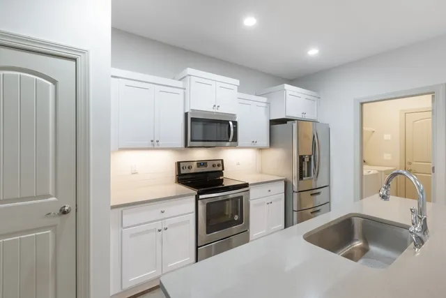 a kitchen with a sink appliances and cabinets