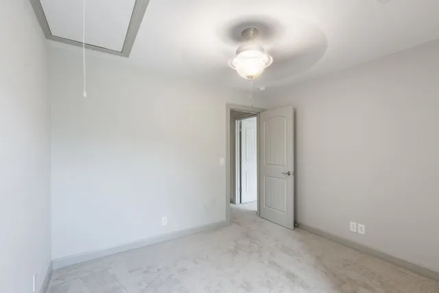 a view of an empty room with a chandelier fan