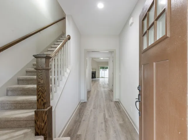 a view of staircase with lots of frames on wall and a window