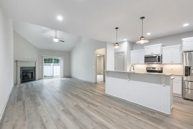 a large kitchen with cabinets wooden floor and stainless steel appliances