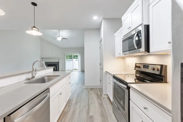a kitchen with stainless steel appliances granite countertop a sink and a stove top oven