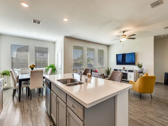 a living room with furniture a dining table and a flat screen tv