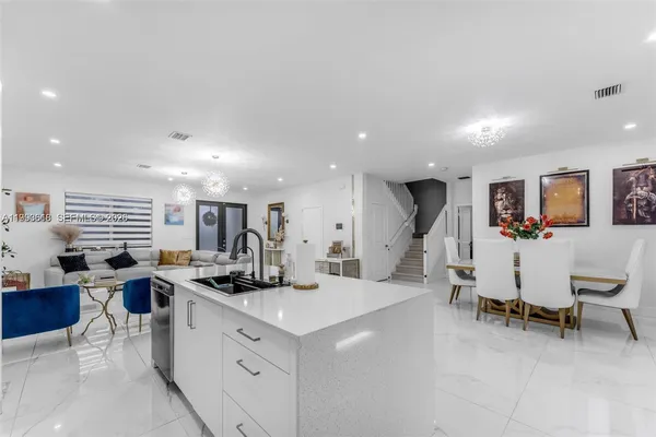 a large white kitchen with a table and chairs