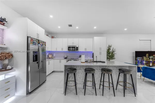 a kitchen with kitchen island cabinets and refrigerator