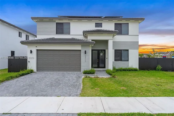 a front view of a house with a yard and garage