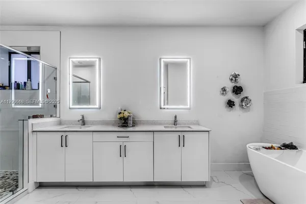 a bathroom with a double vanity sink a mirror and a bathtub