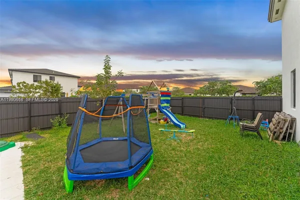 a view of a garden with a slide and a wooden fence