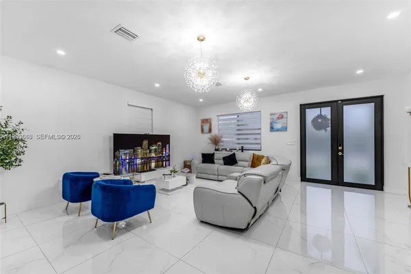 a living room with furniture a flat screen tv and kitchen view