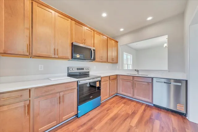 a kitchen with stainless steel appliances granite countertop a stove a sink and a microwave