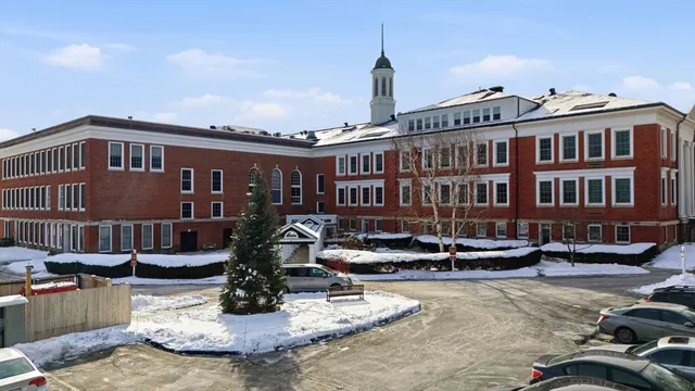 a front view of a building with cars parked