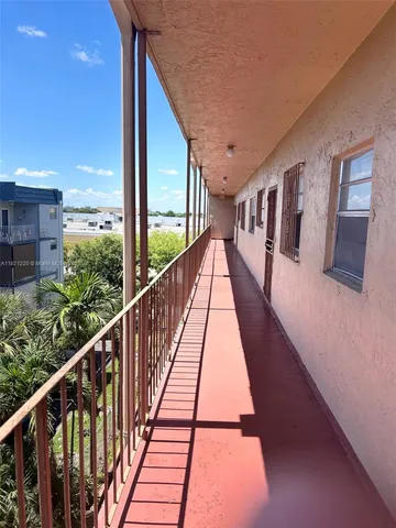 a view of balcony with wooden floor and fence