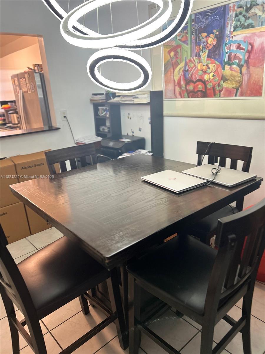 1630 West 46th Street, Unit 511C Hialeah, FL 33012 - Photo 7 of 12 a kitchen with a table chairs and stove