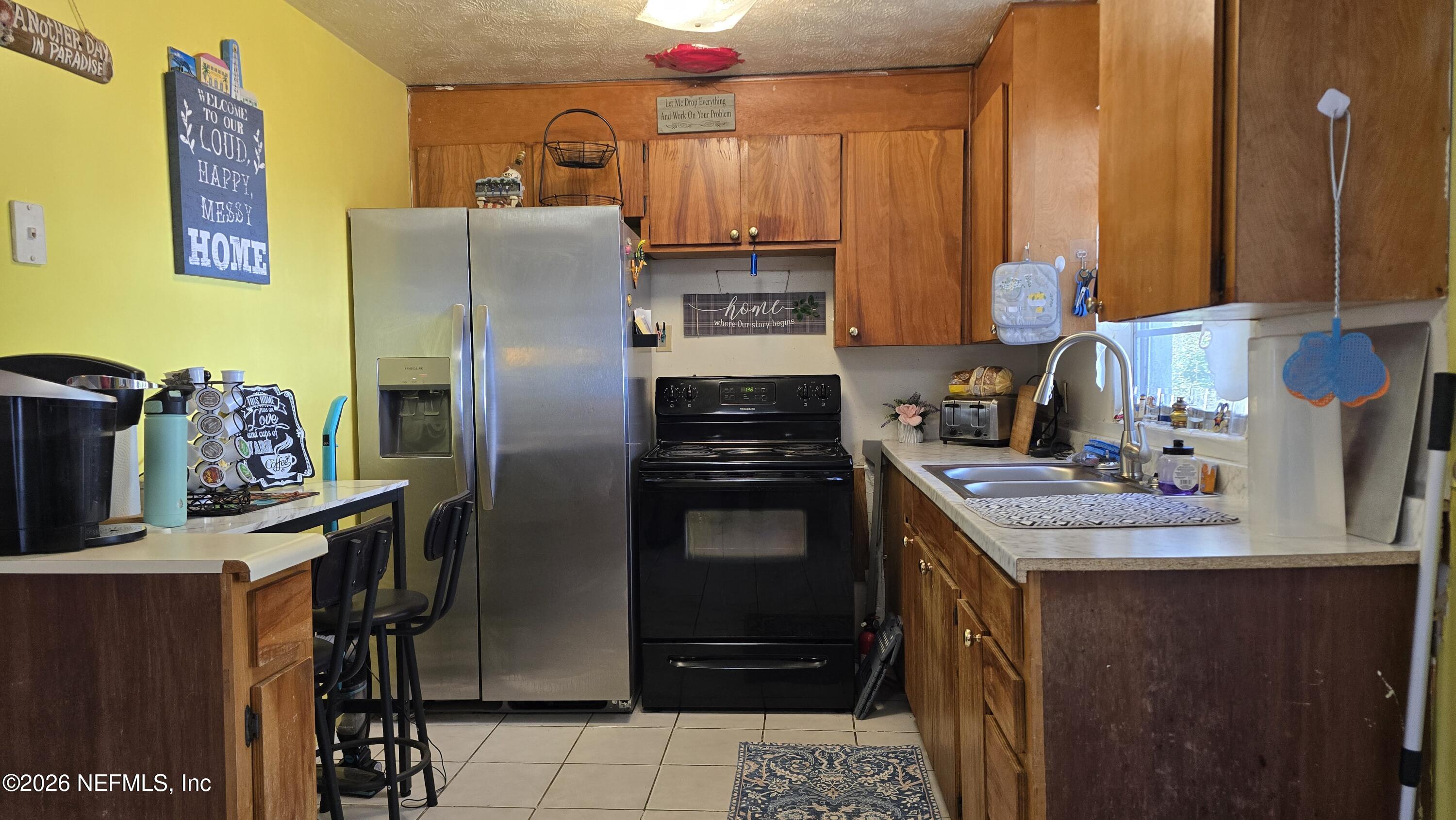 367 Southeast Tribble Street Lake City, FL 32025 - Photo 5 of 12 a kitchen with stainless steel appliances kitchen island granite countertop a refrigerator and a stove