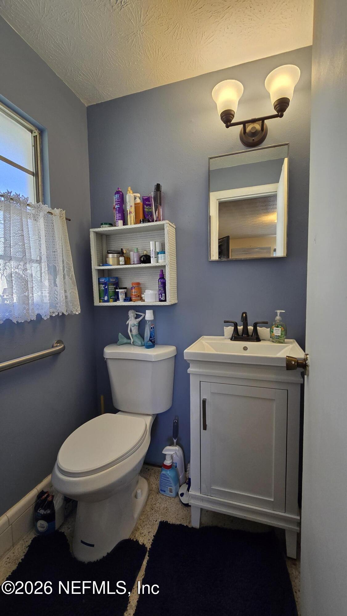 367 Southeast Tribble Street Lake City, FL 32025 - Photo 8 of 12 a bathroom with a toilet a sink and mirror